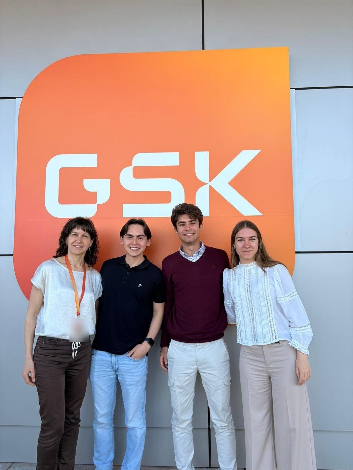 Juan Felipe with his team in front of the GSK sign during the Biopharma & AI Gateway.